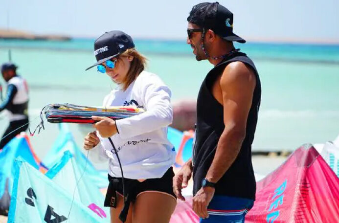 Beginner kitesurfing lesson in El Gouna with Kiteboarding Ways instructor guiding a student on kite setup