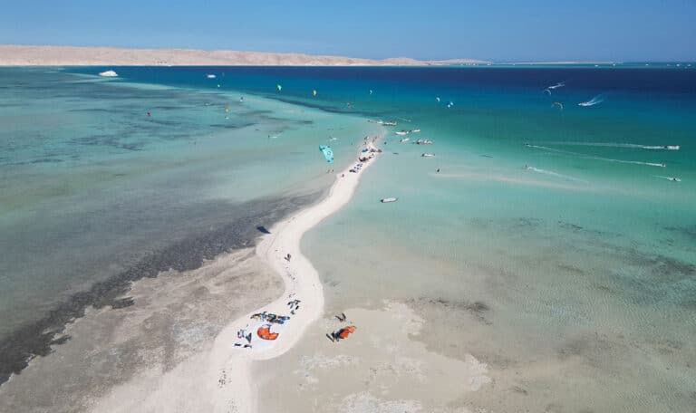 Aerial view of Abu Mungar Island with kitesurfers and turquoise lagoons in the Red Sea