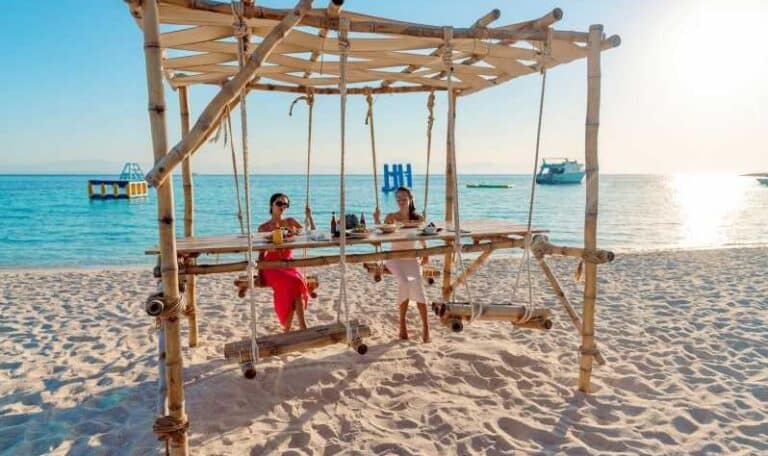 Umm al-Haymat Island beach with bamboo swings and crystal-clear Red Sea waters