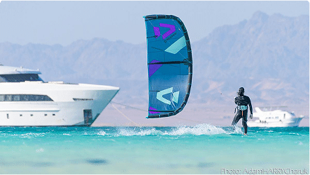 Kitesurfer riding near Ashrafy Island in the Red Sea, Egypt with yachts in the background