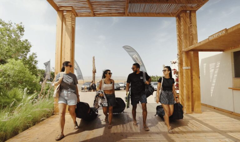 Group of kitesurfers arriving at Kiteboarding Ways El Gouna camp reception with gear bags